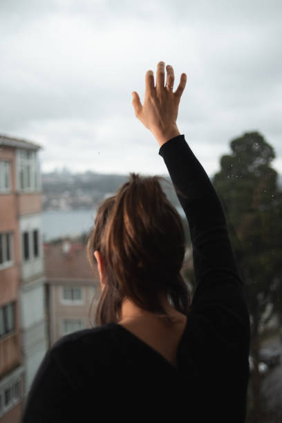 istock Woman looking outside 1214808165