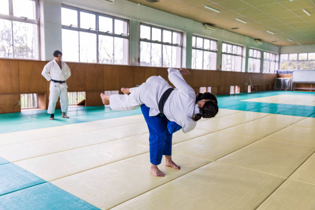istock Young female Judo athlete attacking with “Nage Waza” throwing technique 1214808275