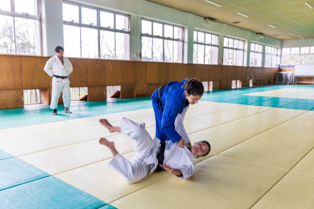 istock Young female Judo athlete attacking with “Nage Waza” throwing technique 1214808294