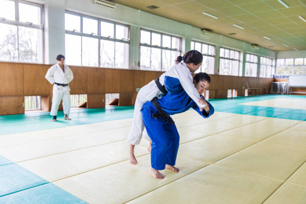 istock Young female Judo athlete attacking with “Nage Waza” throwing technique 1214808824