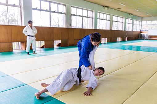Young female Judo athlete attacking with “Nage Waza” throwing technique
