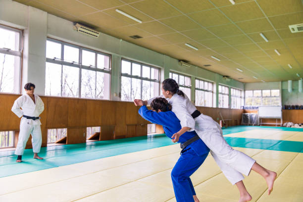 istock Young female Judo athlete attacking with “Nage Waza” throwing technique 1214808856