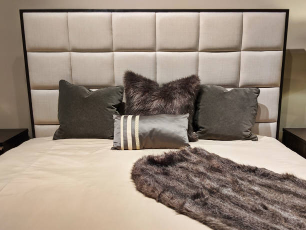istock a cleanly made bed, topped with several small pillows 1214814898