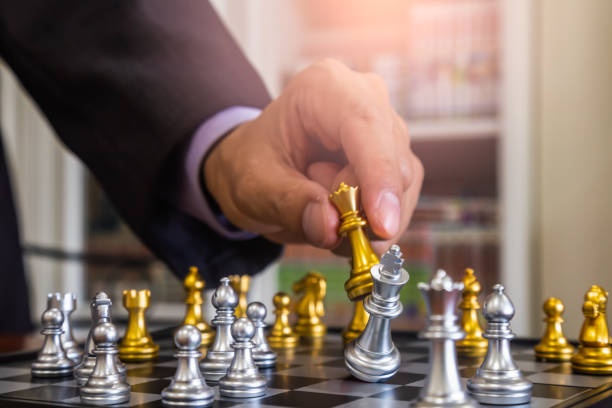 istock Chess game on chess board behind business man background. Business concept to present financial information and marketing strategy analysis. Investment target in global economy and digital commercial. 1214814928