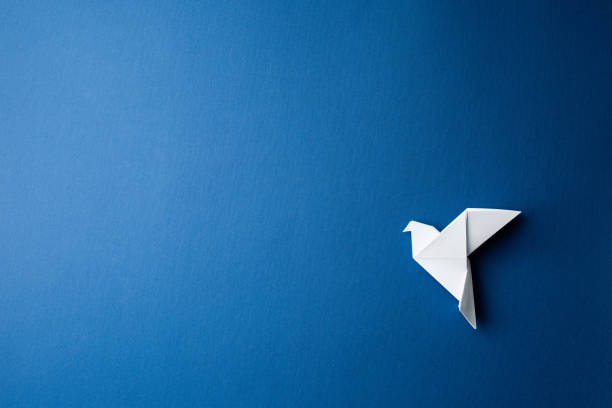 istock Paper pigeon on a blue isolated background. 1214816604