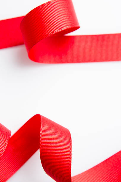 istock Macro beautiful red curly ribbon textured boarder roll isolated on white background with copy area 1214822742