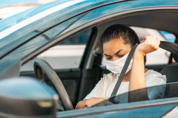 Woman putting on her car seat belt