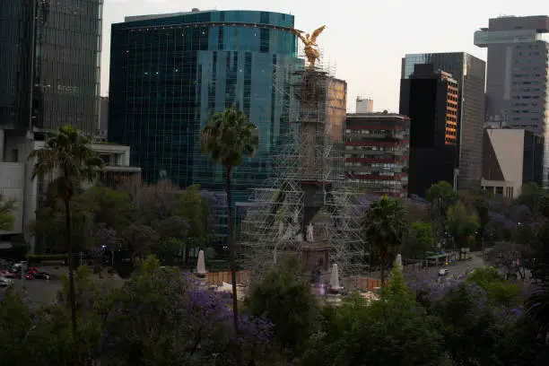 Photo of Golden hour in Mexico City buildings and streets receive the golden orange light of the sun