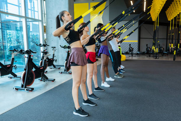 istock Group of friends using TRX in the Gym 1214834329