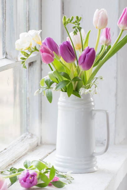 istock beautiful tulips on old white windowsill 1214840254