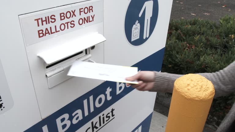 Person Delivers Ballot To Box On Election Day