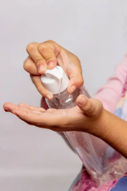 Photo of child putting alcohol gel on his hands, protection against coronavirus