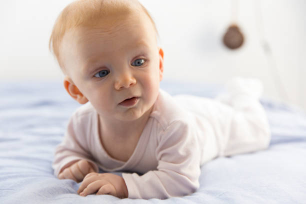 istock Adorable red-haired baby lying on tummy and looking aside 1214847375