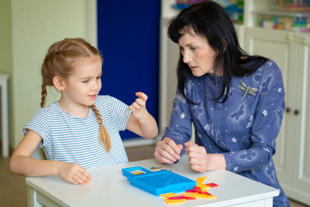 istock teacher and little girl solve mathematical puzzle. 1214851923