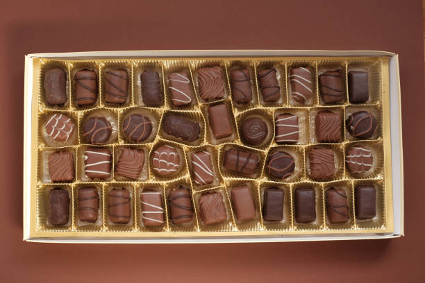 istock chocolate candy set.Box of chocolates close-up on a dark brown background.assorted chocolate sweets.Chocolate candies set in an open box. top view. sweet dessert 1214854820