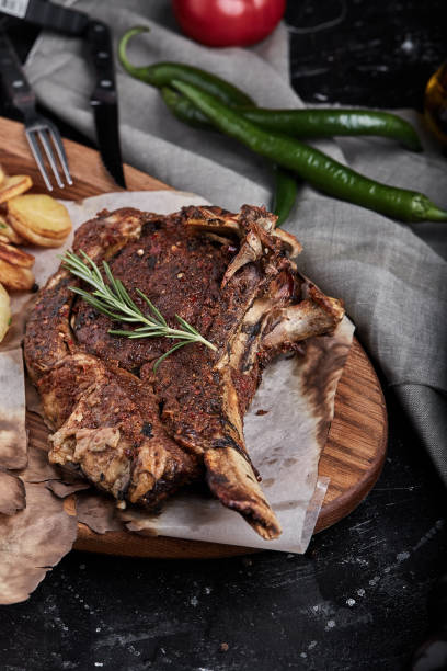 istock Tomahawk steak with vegetables and a knife on the table. Grilled meat with grilled vegetables and fresh vegetables on the table 1214854852