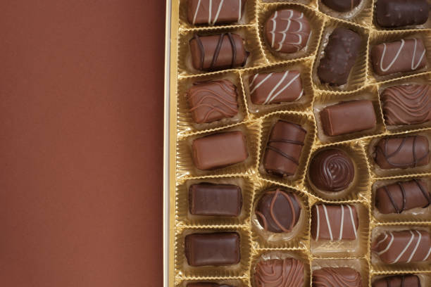 istock chocolate candy set.Box of chocolates close-up isolated on a brown background. assorted chocolate sweets.Chocolate candies set in an open box. top view.sweet dessert closeup 1214854868