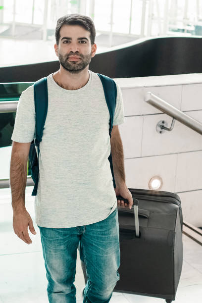 istock Smiling young man walking with luggage 1214855627