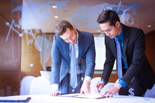 istock Two partners signing contract with financial analysis graphs 1214856845