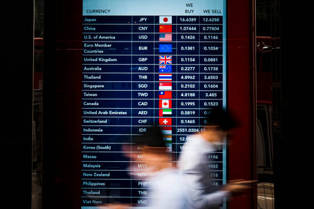 Foreign currency exchange monitor People walk in front of a foreign currency exchange monitor . currency exchange stock pictures, royalty-free photos & images