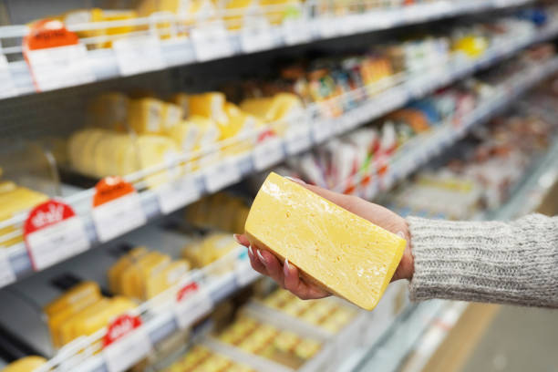 istock Woman's hand with cheese in grocery store. 1214860550