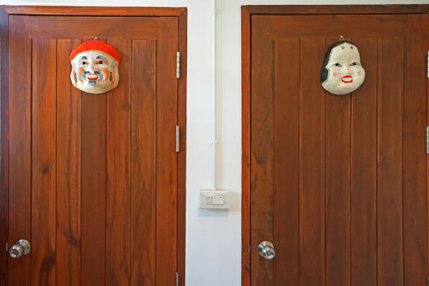 Close up wooden public restroom door separated by traditional Japanese mask Bathroom Indoor decorating idea toilet sign in japanese style stock pictures, royalty-free photos & images