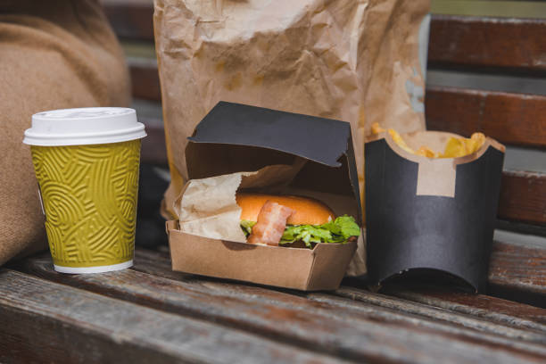 istock fast food. big burger with cup of tea on a bench. 1214860624