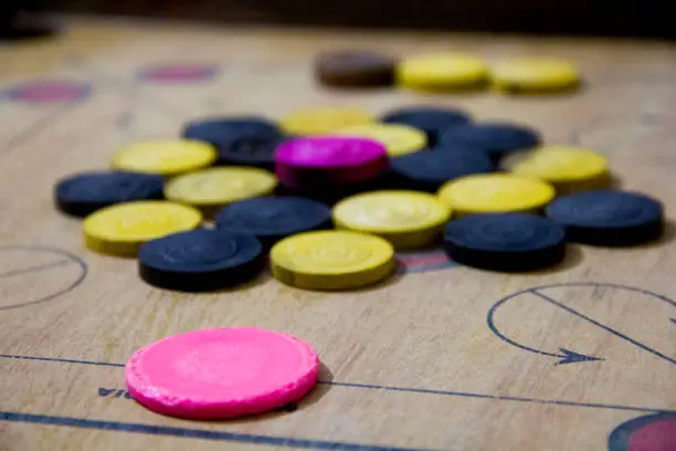 Photo of A game of carom set and ready to play. A game of carrom with pieces carrom man on the board carrom. Carom board game, selective focus.