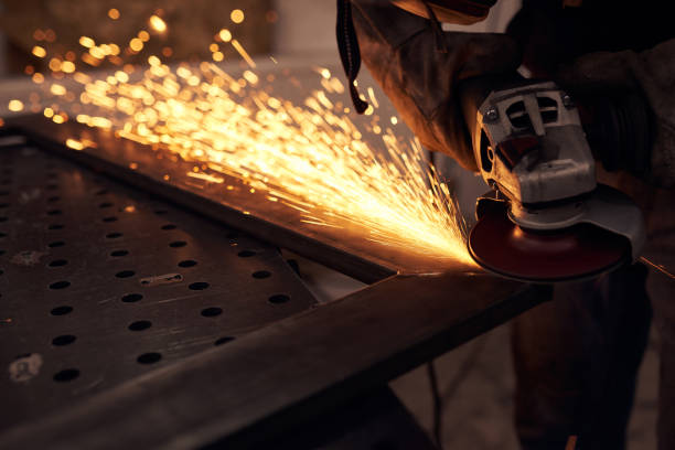 istock Worker cutting metal with grinder. Sparks while grinding iron 1214860967