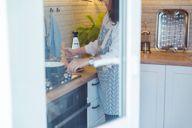 istock woman cooking pancakes view through window 1214861066