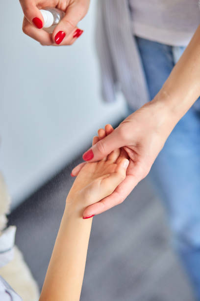 istock Mother and daughter using wash hand sanitizer gel. 1214861735