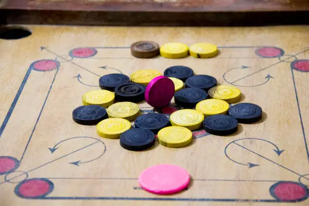 Photo of A game of carom set and ready to play. A game of carrom with pieces carrom man on the board carrom. Carom board game, selective focus.