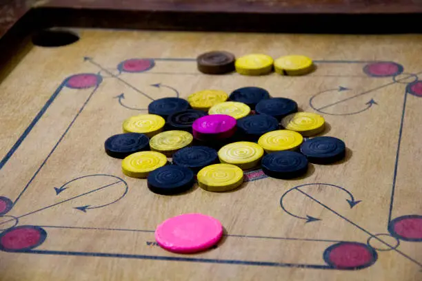 Photo of A game of carom set and ready to play. A game of carrom with pieces carrom man on the board carrom. Carom board game, selective focus.