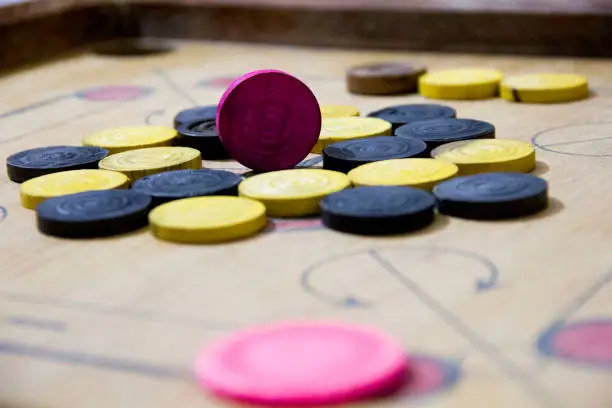 Photo of A game of carom set and ready to play. A game of carrom with pieces carrom man on the board carrom. Carom board game, selective focus.