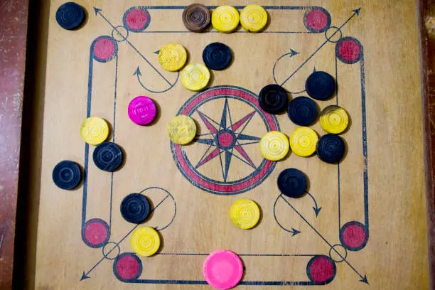 Photo of A game of carom set and ready to play. A game of carrom with pieces carrom man on the board carrom. Carom board game, selective focus.