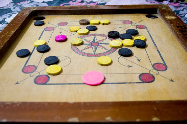 Photo of A game of carom set and ready to play. A game of carrom with pieces carrom man on the board carrom. Carom board game, selective focus.