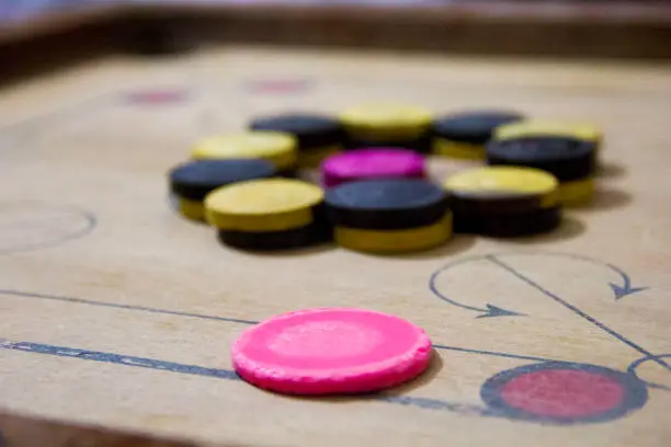 Photo of A game of carom set and ready to play. A game of carrom with pieces carrom man on the board carrom. Carom board game, selective focus.