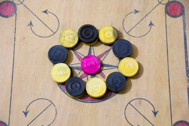 Photo of A game of carom set and ready to play. A game of carrom with pieces carrom man on the board carrom. Carom board game, selective focus.