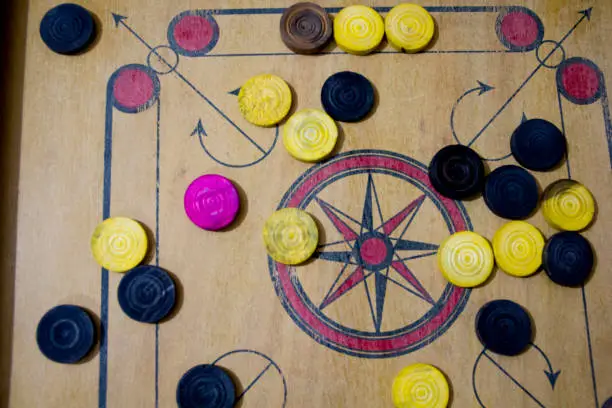 Photo of A game of carom set and ready to play. A game of carrom with pieces carrom man on the board carrom. Carom board game, selective focus.