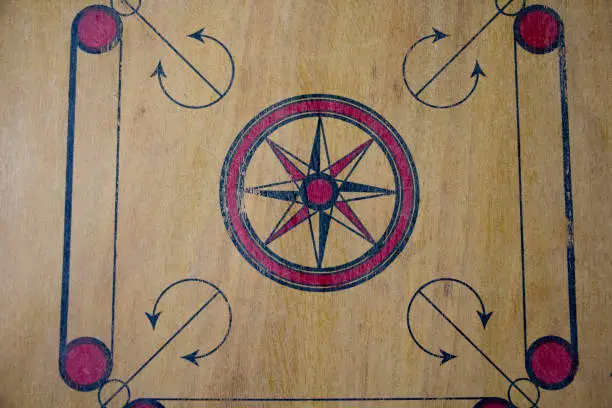 Photo of A game of carom set and ready to play. A game of carrom with pieces carrom man on the board carrom. Carom board game, selective focus.