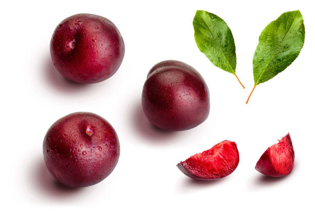 istock Plums from different angles and leaves isolated on white background. Appetizing and healthy red plums, whole and cut into segments with an aspect of illustration. 1214869859