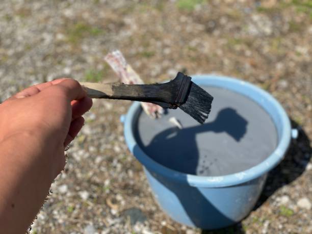 istock Man holding Paintbrush against bucket - high angle view / Personal perspective 1214870064