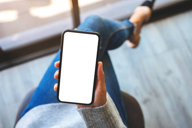 istock a woman holding mobile phone with blank white screen 1214871216