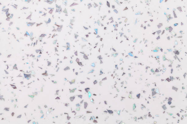 istock Grainy white background with gray shiny spots from foil sparkles. Texture backdrop with small crumb pattern. 1214871782
