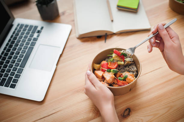 A woman has lunch and works at home. Top view. Space for text in the smartphone A woman has lunch and works at home. Close-up. Top view. Space for text in the smartphone ladies lunch stock pictures, royalty-free photos & images