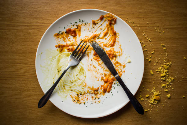 istock Empty dirty plate after a meal with fork and knife, top view 1214873537