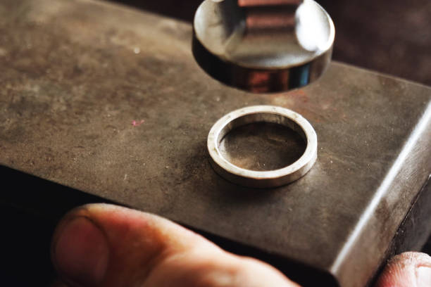 istock Close up of a goldsmith's hand making a gold or silver ring or a diamond using goldsmith's tools 1214873827