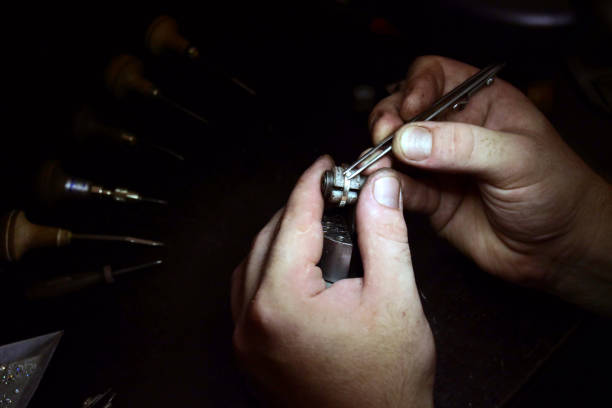 istock Close up of a goldsmith's hand making a gold or silver ring or a diamond using goldsmith's tools 1214873987