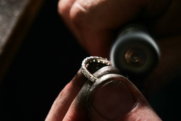 istock Close up of a goldsmith's hand making a gold or silver ring or a diamond using goldsmith's tools 1214875168