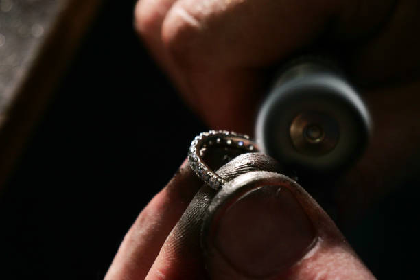 istock Close up of a goldsmith's hand making a gold or silver ring or a diamond using goldsmith's tools 1214875289
